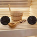 SaunaLife bucket, ladle, thermometer and hygrometer arranged on a cedar sauna bench