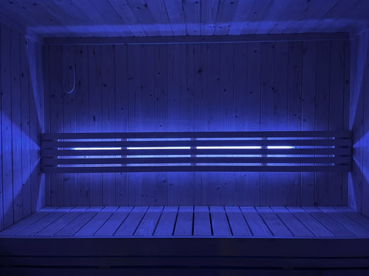 SaunaLife X7MOOD LED lighting glowing blue across a wood sauna bench