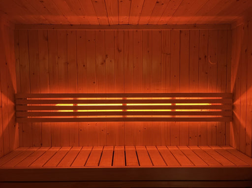 SaunaLife X7MOOD LED lighting glowing warm orange across a cedar sauna bench
