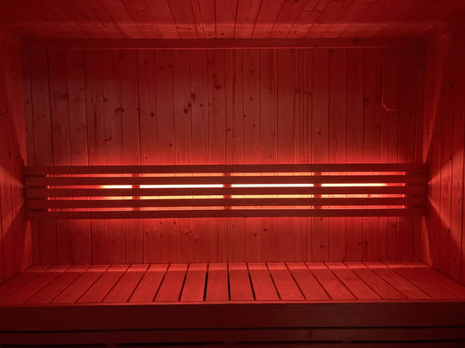 SaunaLife X7MOOD LED lighting casting deep red across a wood sauna