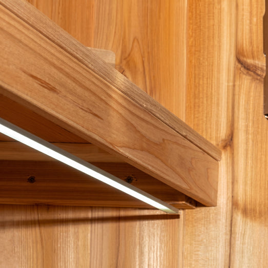 Close-up of the SaunaLumin Ambiance LED strip mounted beneath a cedar sauna bench