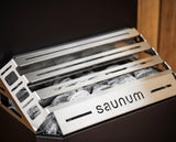 Close-up of the Saunum Air 5 stainless stone basket and sauna stones, branded detail