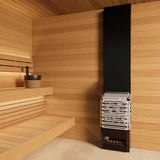 Saunum Air 7 heater tower in a warm cedar sauna corner with bench and bucket