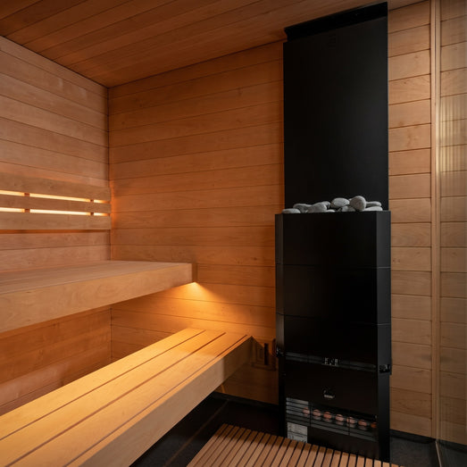Saunum Air black sauna heater mounted in the corner of a warm cedar sauna