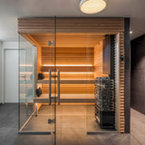 Saunum Air heater installed in a modern glass-front sauna with lit wood benches