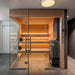 Saunum Air heater installed in a modern glass-front sauna with lit wood benches