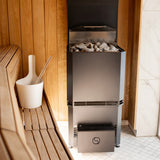Saunum Air stainless heater loaded with stones next to a white sauna bucket