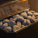 Close-up of rounded sauna stones filling the top tray of the Saunum Air heater