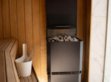 Saunum Air L 10 heater and ladle bucket in a cedar sauna beside a marble wall