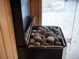 Close-up of the Saunum Air L 10 heater stone basket loaded with rounded sauna stones