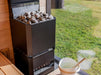 Saunum Air L 10 heater with stones in a sauna overlooking a green garden window