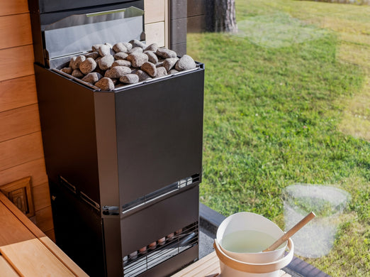 Saunum Air L 10 heater with stones in a sauna overlooking a green garden window