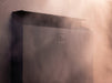 Atmospheric detail of the Saunum Air L 13 heater top edge with warm light and rising steam