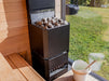 Saunum Air L 15 heater loaded with stones beside a window overlooking a green lawn