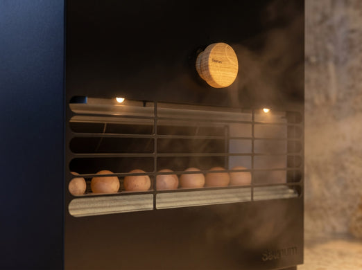 Steam venting through the Saunum Air L 15 grille with a round wooden control knob