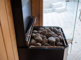 Close-up of the Saunum Air L 15 stone basket filled with rounded sauna stones