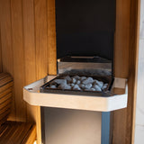 Angled view of the Saunum Air L heater stone tray filled with gray sauna stones