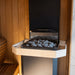 Angled view of the Saunum Air L heater stone tray filled with gray sauna stones