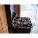 Close-up of the Saunum Air L heater top loaded with brown rounded sauna stones