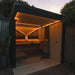 Saunum Air L heater installed in a backlit outdoor sauna cabin at dusk