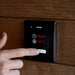 Finger tapping Saunum Air L wall controller displaying timer and 90C in Nordic mode