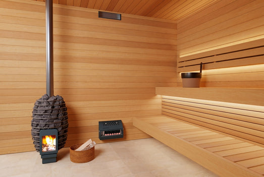 Saunum AirSolo Wall installed low in a warm cedar sauna beside wood stove
