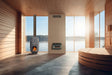 Saunum AirSolo Wall mounted in a bright lakeside sauna with wood stove