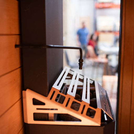 Saunum Auto Leil dispenser arm and bracket mounted to sauna heater side