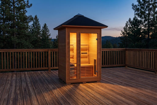 SunRay Bristow 2-person outdoor traditional sauna with black metal roof and lit interior on a wooden deck at dusk