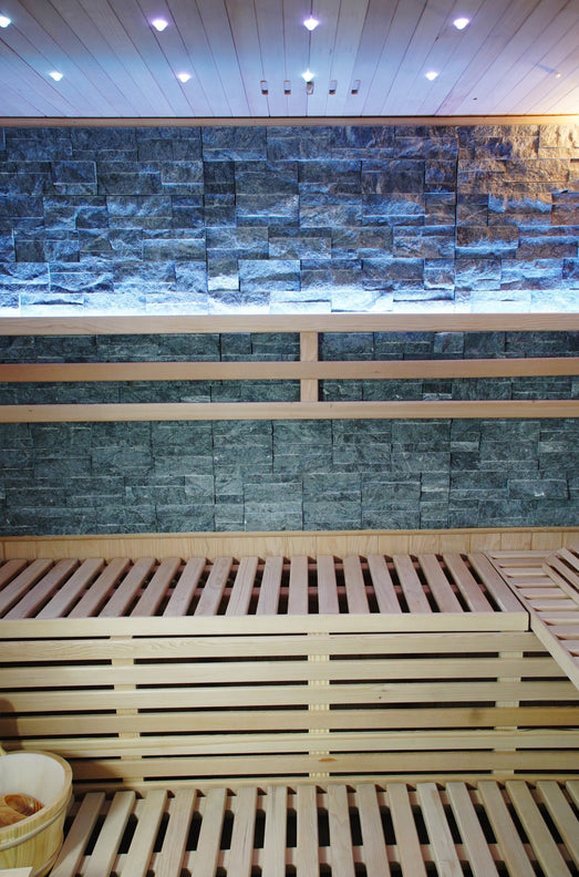 Slate-colored cultured stone back wall above the SunRay Galaxie double benches
