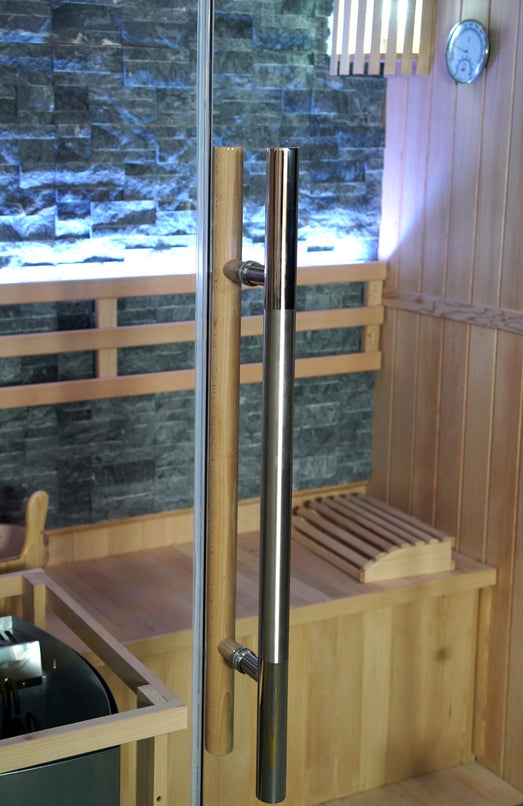 Stainless steel bar handle on the glass door of the SunRay Rockledge sauna, slate-colored stone wall behind