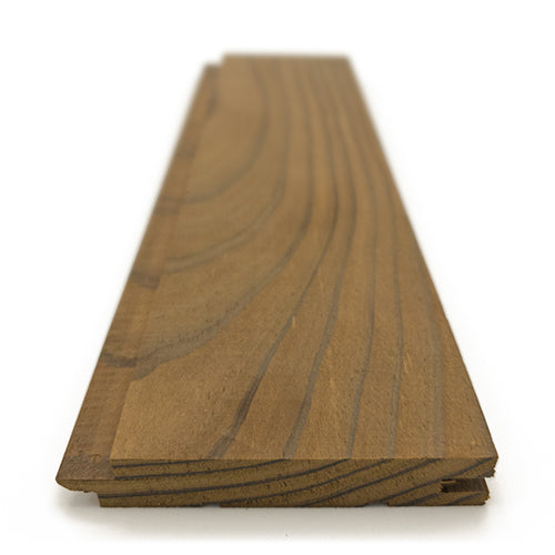 Thermo-Radiata Pine 1x4 tongue-and-groove paneling board, low angled view along the length with curved grain and stepped edge